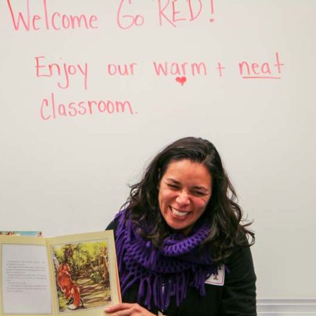 a person smiling at a whiteboard