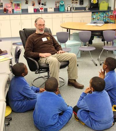 a person sitting in a chair with a group of children