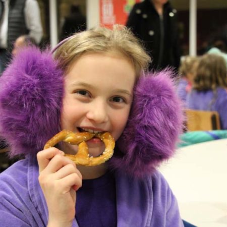 a young child eating a pretzel
