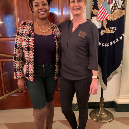 two women standing together smiling