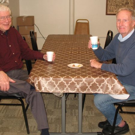 a couple of old men sitting at a table