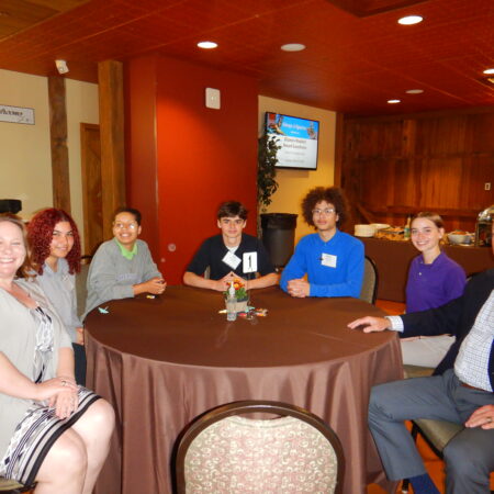 a group of people sitting around a round table