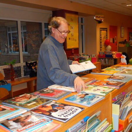 a person standing at a table with books