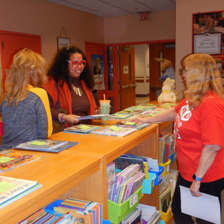 a group of women standing at a desk
