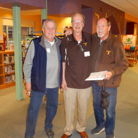 a group of men standing in a library