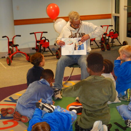 a person reading a book to children