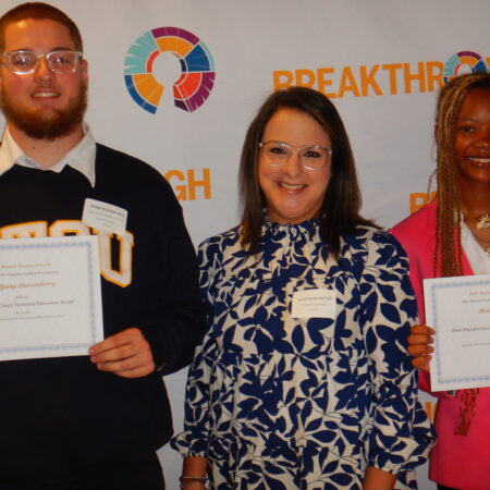 a group of people holding certificates