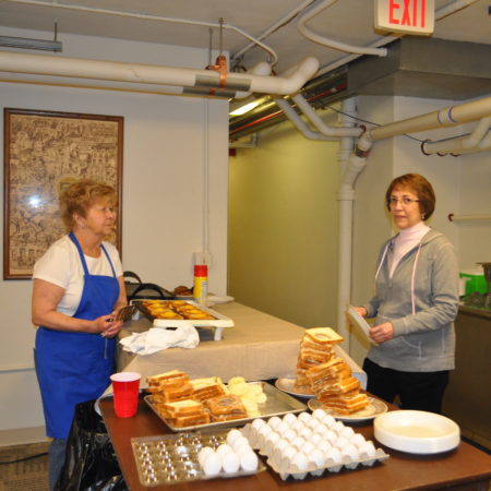 a person standing next to a table with food