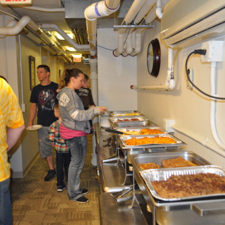 a group of people standing in a line of food