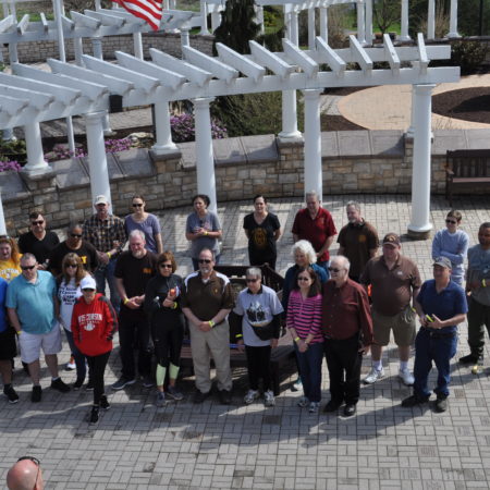 a group of people standing in front of a pergola