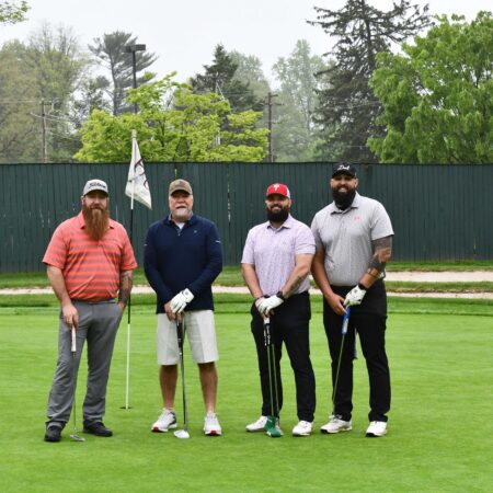 a group of men standing on a golf course