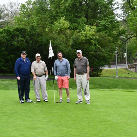 a group of men standing on a golf course