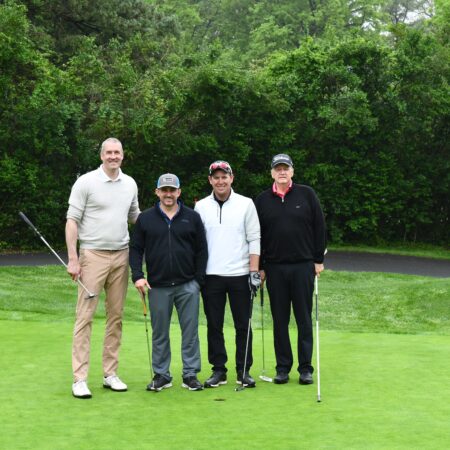 a group of men standing on a golf course