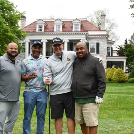 a group of men standing in front of a house