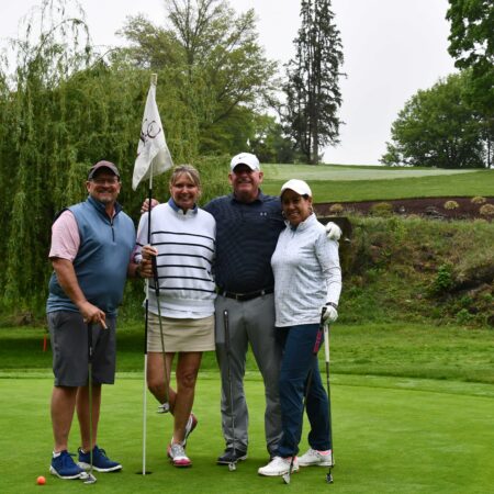 a group of people standing on a golf course