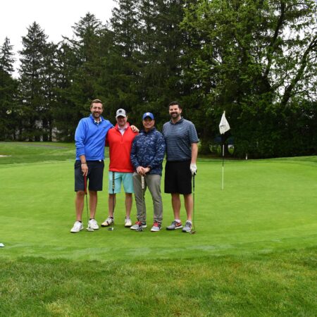 a group of men standing on a golf course