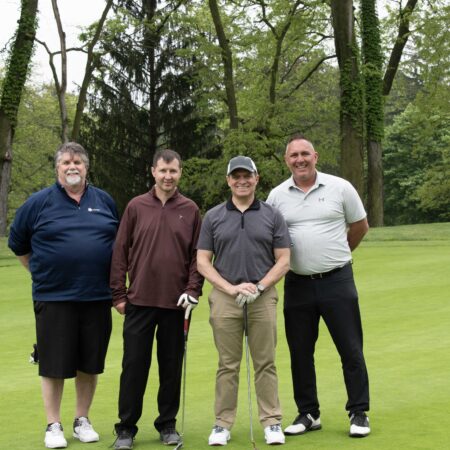 a group of men standing on a golf course