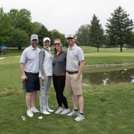 a group of people standing on a golf course