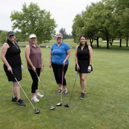 a group of women holding golf clubs
