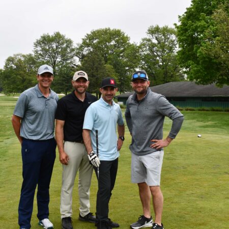 a group of men standing on a golf course