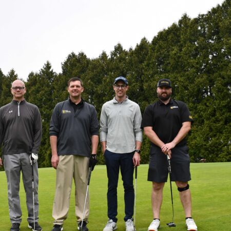 a group of men standing on a golf course