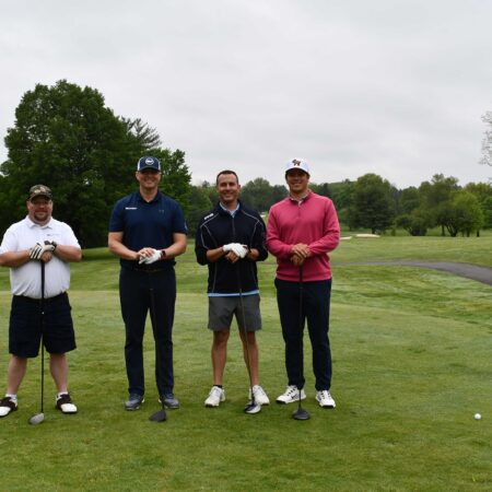 a group of men standing on a golf course