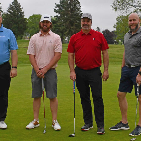a group of men standing on a golf course