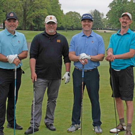 a group of men standing on a golf course