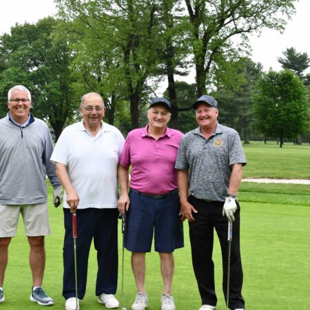 a group of men standing on a golf course