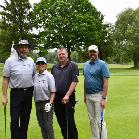 a group of people standing on a golf course