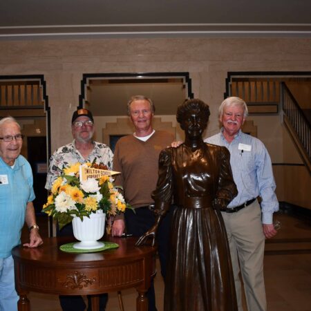 a group of people standing next to a statue