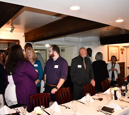a group of people standing around a table
