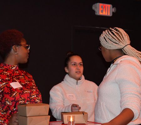 a group of women standing around a table
