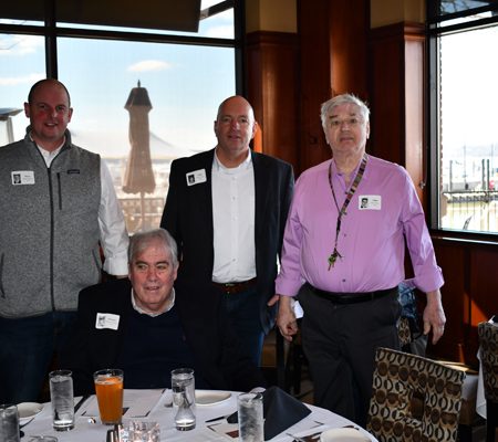 a group of men standing around a table