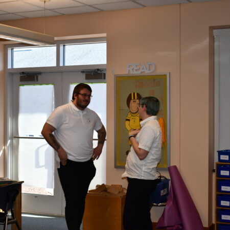 a person standing in a room with a person standing in front of him