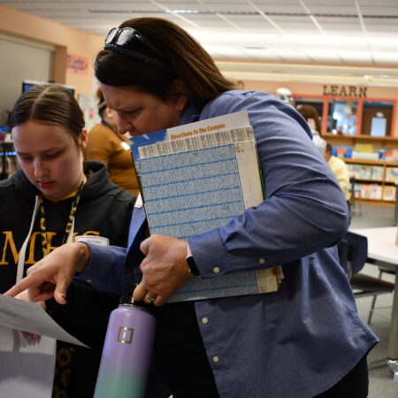 a person holding a book and looking at a person