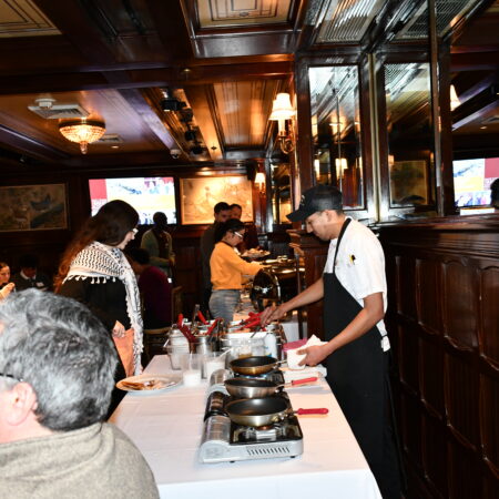 a person standing at a table with people in the background