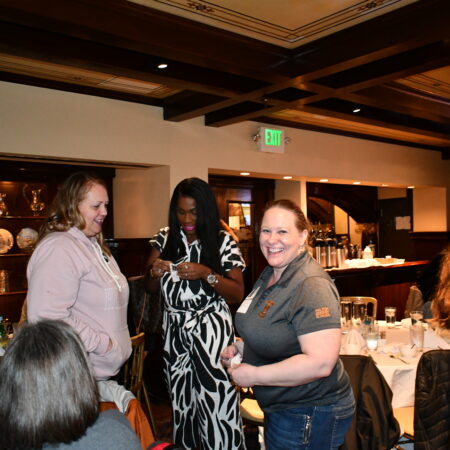 a group of women standing around a table