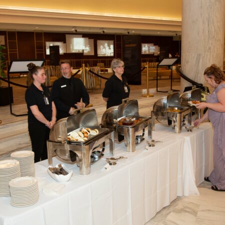 a group of people standing around a buffet table