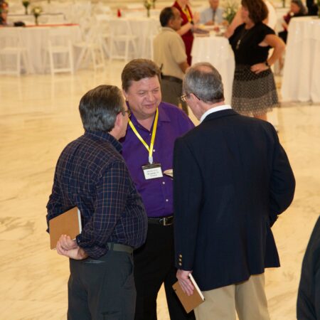 a group of men talking in a room