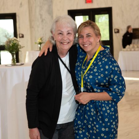 two women standing together smiling