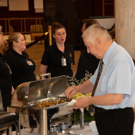 a person serving food at a buffet