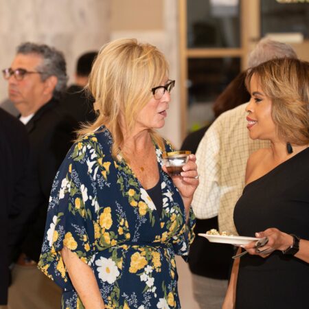 a person holding a drink and a person holding a plate
