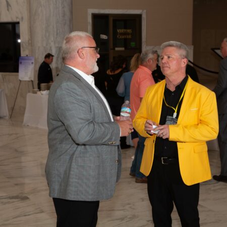 a person in a yellow jacket talking to another person
