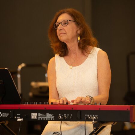 a person in a white dress playing a keyboard