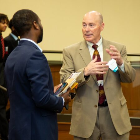 a person in a suit talking to another person
