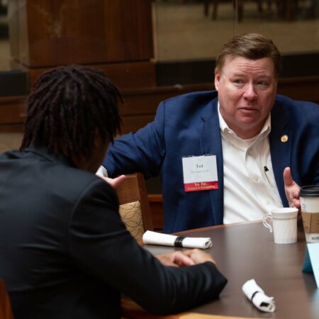 a person in a suit talking to another person