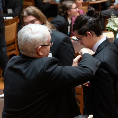 a person in a suit fixing a person's tie