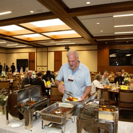 a person serving food at a buffet