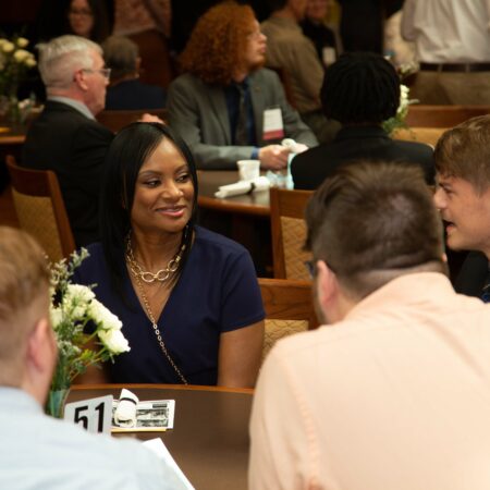 a person sitting at a table with other people